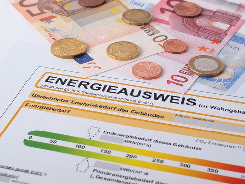 Energieausweis liegt mit Münzen auf Tisch