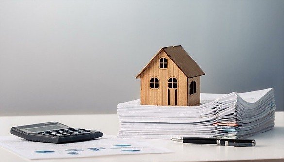 Modellhaus steht auf Stapel mit Dokumenten